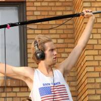 a male boom operator holding the boom pole in place